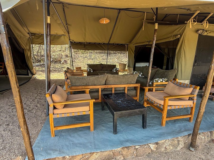 Lounge tent interior with wooden armchairs, cushions and a pendant lamp